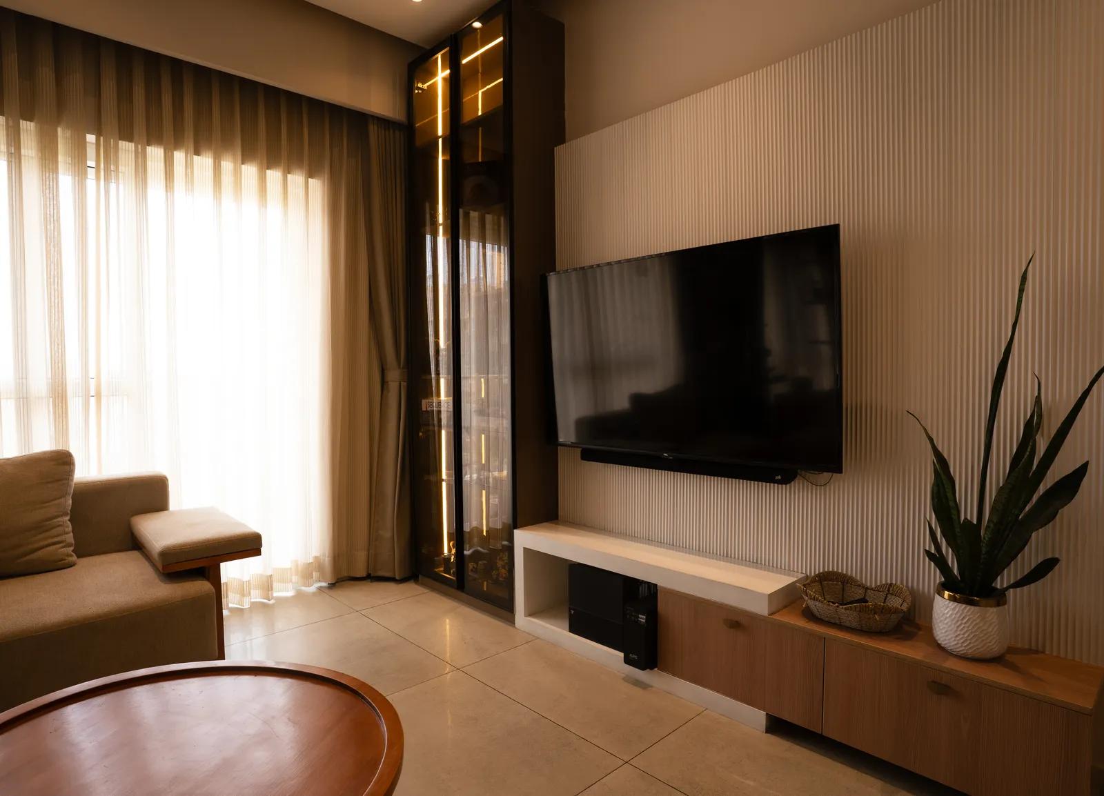 Living room TV wall with display cabinet and sheer curtains — Amlan's Residence